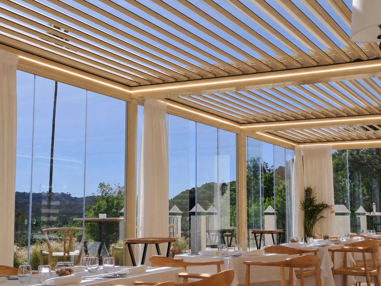 Pérgola bioclimática modular con iluminación LED en terraza de restaurante