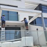 Instaladores trabajando en un proyecto de pérgola de aluminio a medida