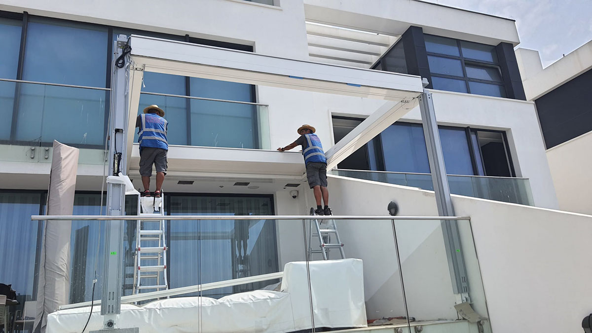 Instaladores trabajando en un proyecto de pérgola de aluminio a medida