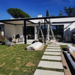 Aluminium pergola being installed beside an existing home, transforming a former lawn area into a covered outdoor space