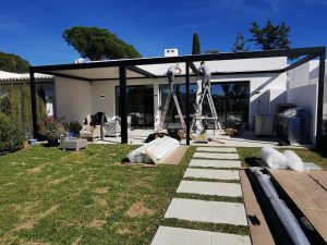 Aluminium pergola being installed beside an existing home, transforming a former lawn area into a covered outdoor space