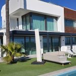 Aluminium bioclimatic pergola integrated into a modern villa terrace beside a swimming pool